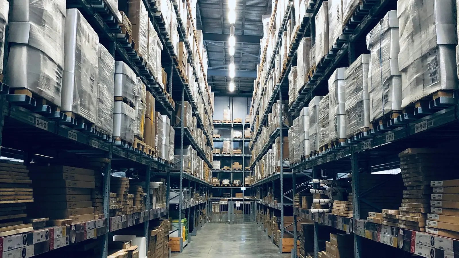 An aisle of warehouse racking stacked to the ceiling