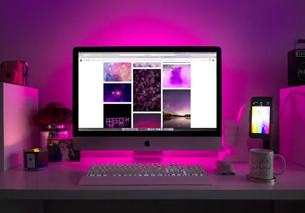 A laptop open on a desk beside a window